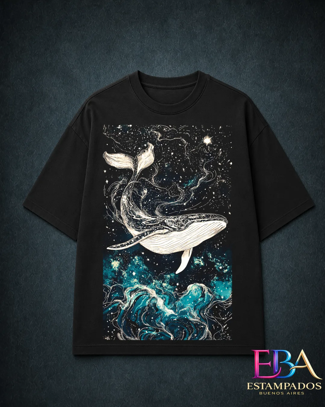 Remera negra con una ballena ilustrada en blanco sobre un cielo estrellado y olas turquesa