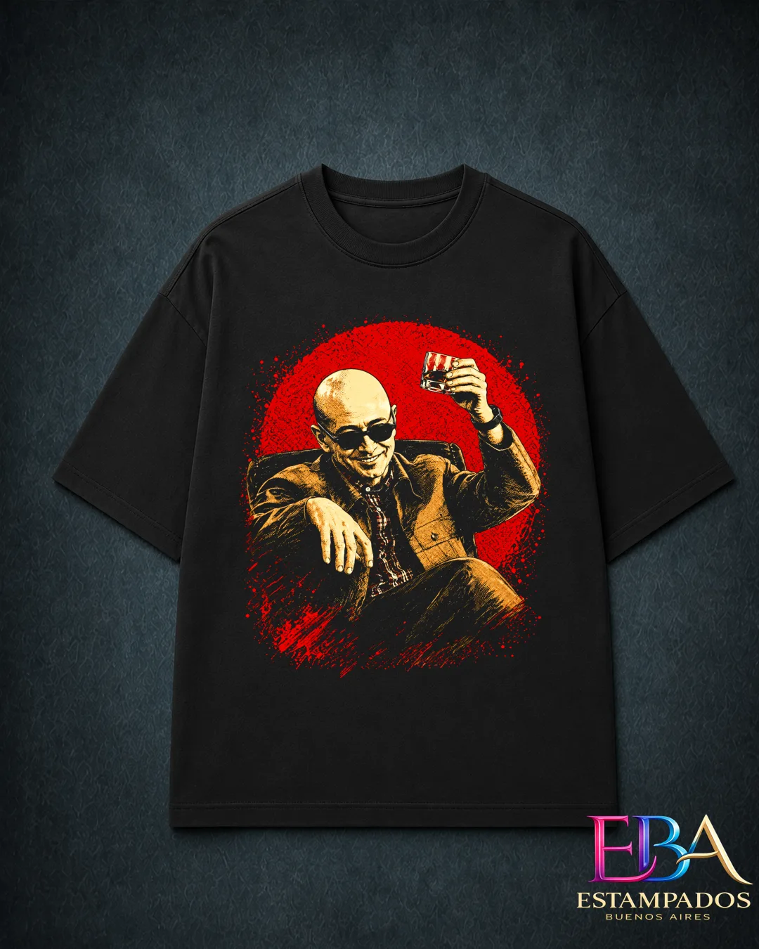 Remera negra con ilustración de Indio Solari de traje y lentes, levantando un vaso sobre un círculo rojo