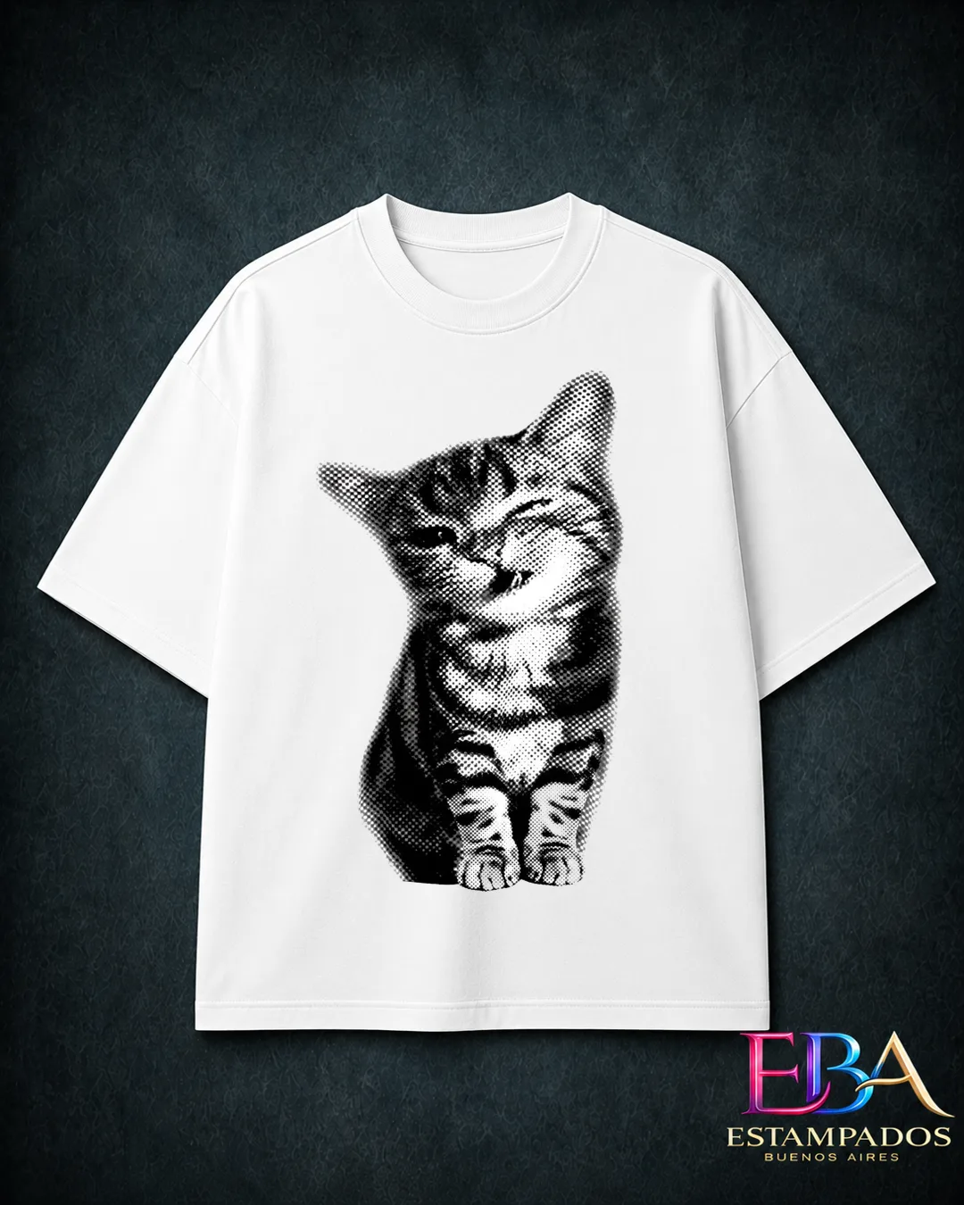 Remera blanca con ilustración halftone en blanco y negro de un gatito atigrado sentado
