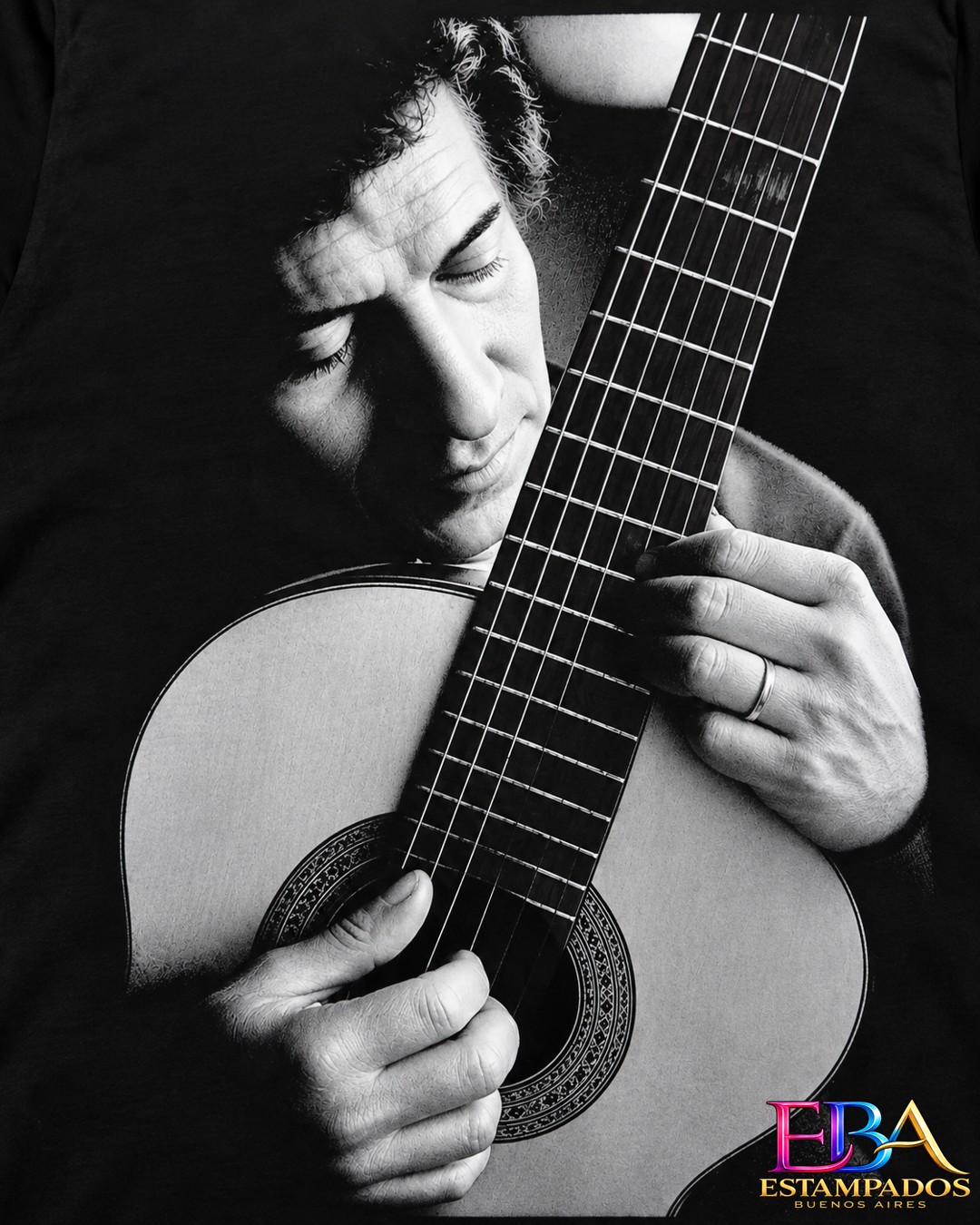 Remera negra con estampado en blanco y negro de un guitarrista tocando una guitarra criolla